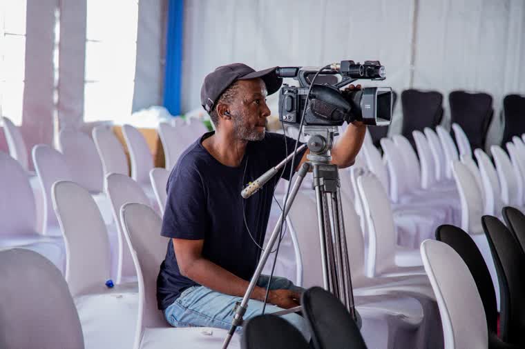 Camera operator setting up in an empty hall before doors