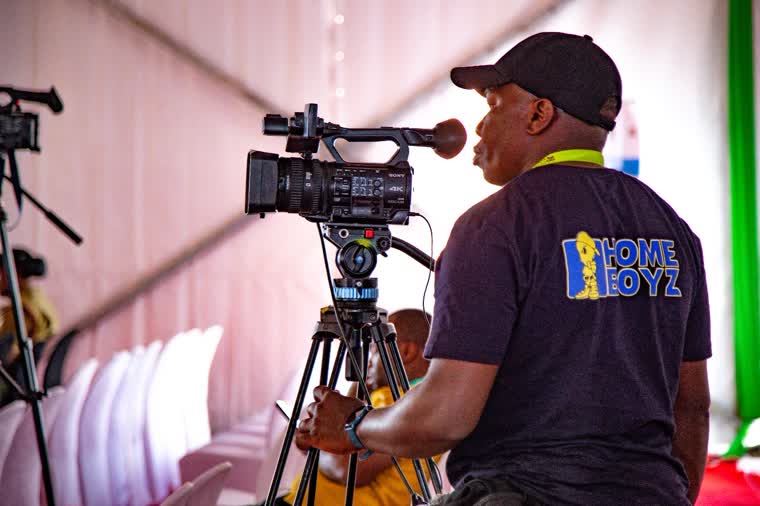 Camera operator working under a marquee canopy