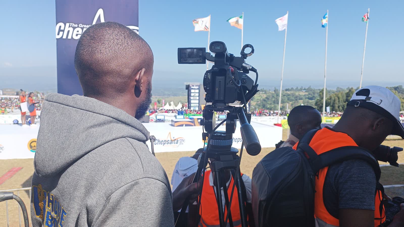 Camera operator in a Homeboyz hoodie filming the Chepsaita Cross Country